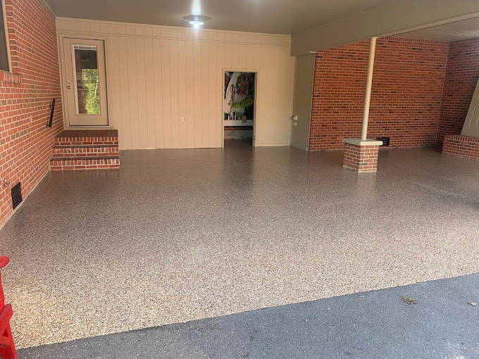 Spacious residential garage with tan decorative flake epoxy floor coating and brick wall accents