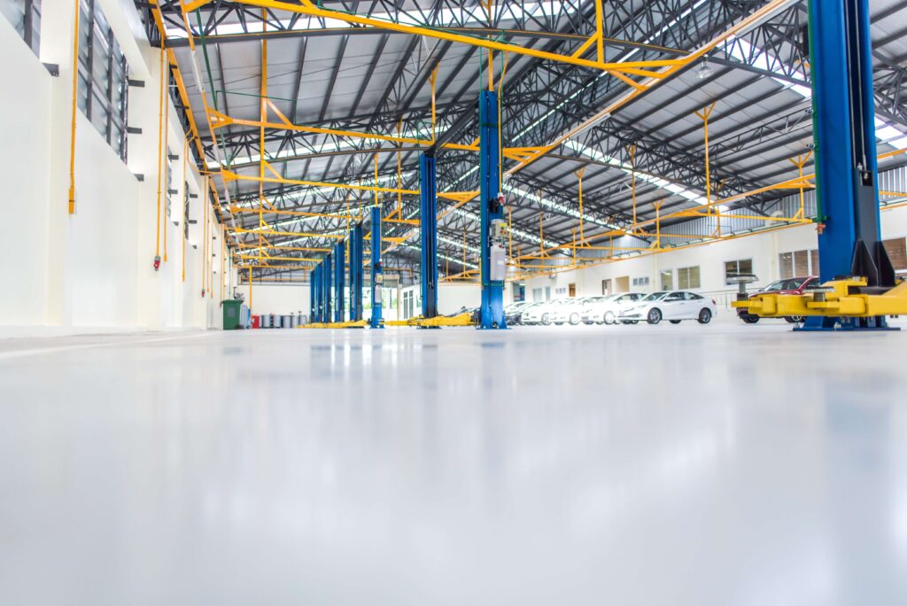 Commercial auto repair shop with polished seamless epoxy floor coating and hydraulic vehicle lifts